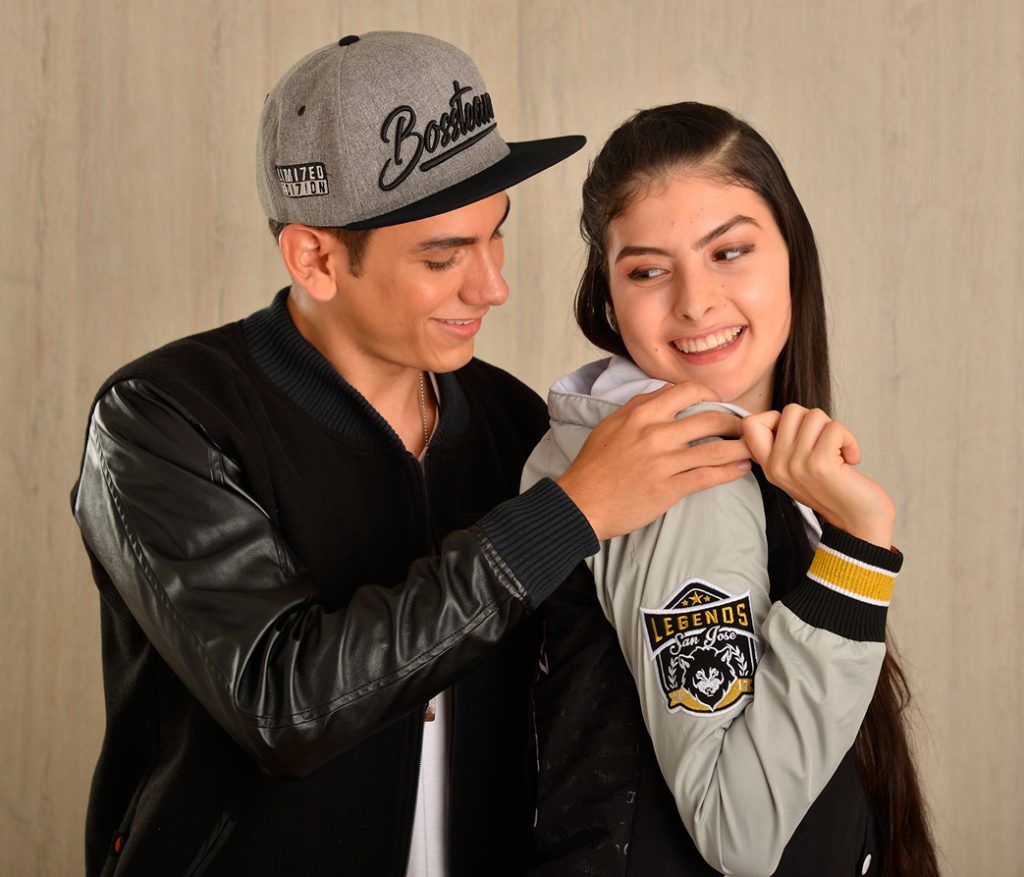 Dos personas con chaquetas oscuras de la colección Varsity en una pose cercana.