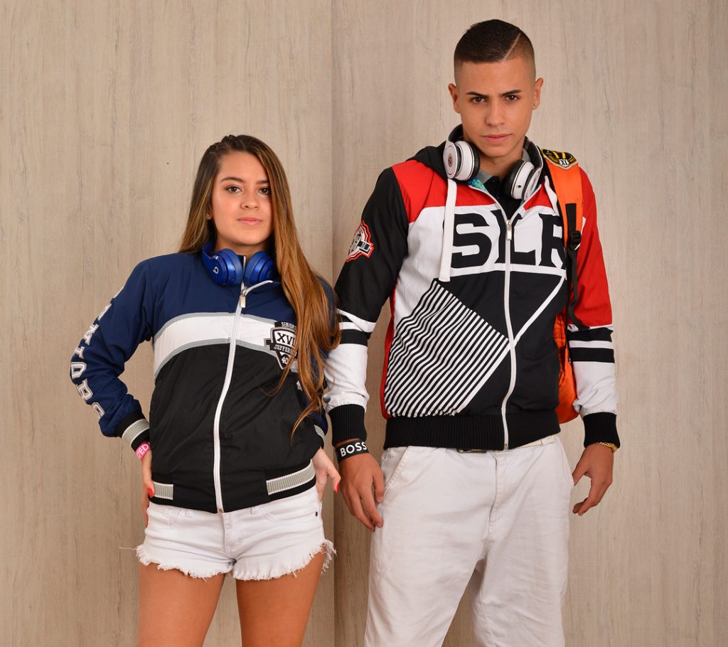 Dos personas con chaquetas deportivas personalizadas y audífonos.